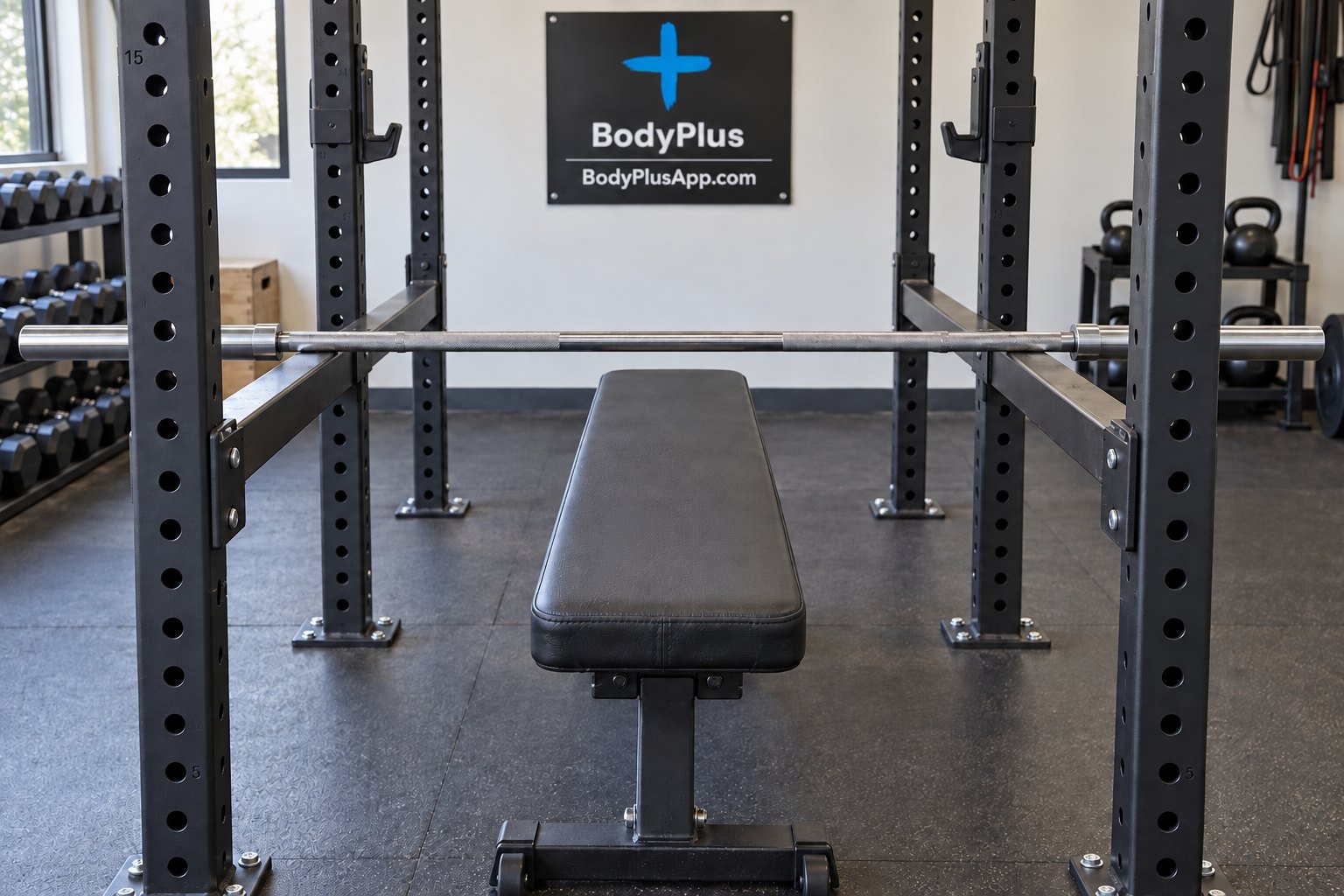 Barre olympique posée sur les supports d'un rack à squat, avec un banc plat au centre d'une salle de sport.
